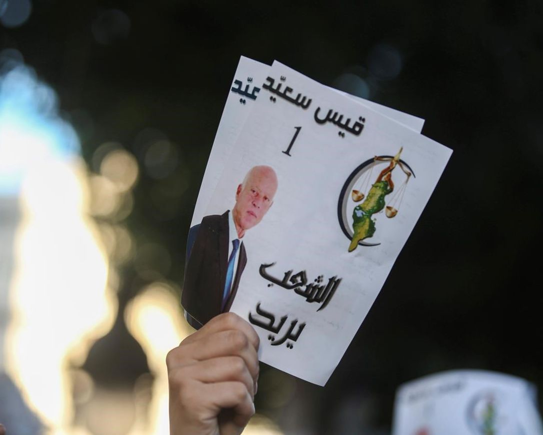 A supporter of Tunisian President Kais Saied holding a promotional flyer during the presidential elections he won, 19 October 2019. AP, Mosa'ab Elshamy