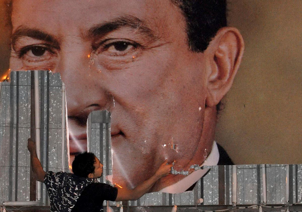An anti-government protester defaces a picture of Egypt's President Hosni Mubarak in Alexandria, north of Cairo, Egypt, 25 January 2011. Reuters, Stringer, File Photo.