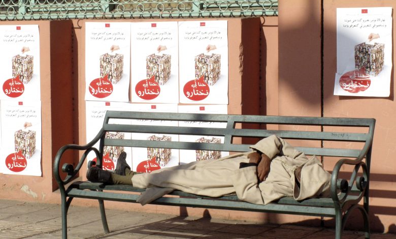 رجل نائم أسفل ملصقات انتخابية تقول "نستطيع أن نختار" قبيل الانتخابات البرلمانية بالمغرب بالخامس والعشرون من نوفمبر 2011، مراكش، 18 نوفمبر 2011. رويترز، جان بلوندن.