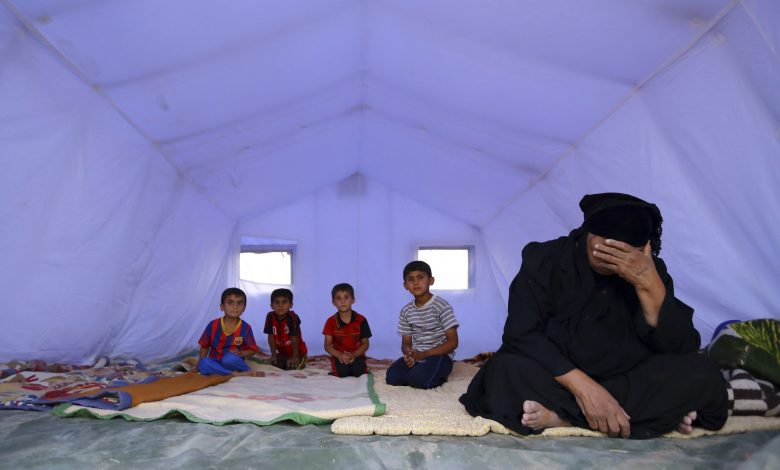 An Iraqi family, which fled from the violence in Mosul following the city’s fall to ISIL, sits inside a tent at a camp on the outskirts of Arbil in Iraq's Kurdistan region, 12 June 2014. Reuters, stringer.