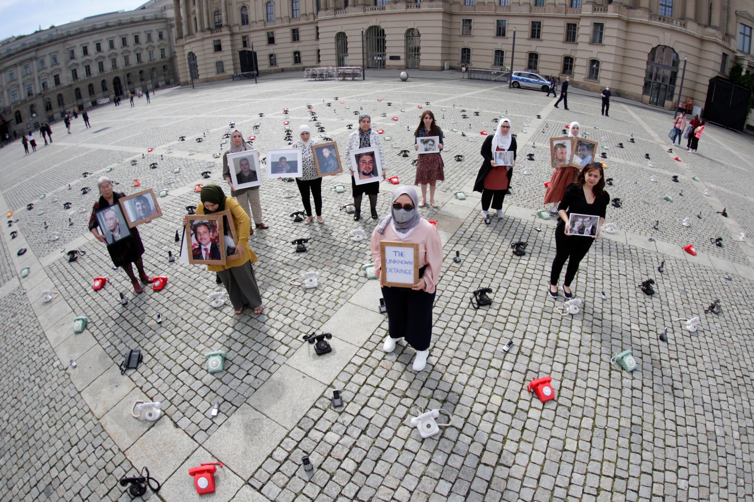 Syrian Women hold portraits and a placard as a call to governments to do more to seek information about detained people in Syria - Berlin, Germany, 28 August 2021. Reuters, Hannibal Hanschke.