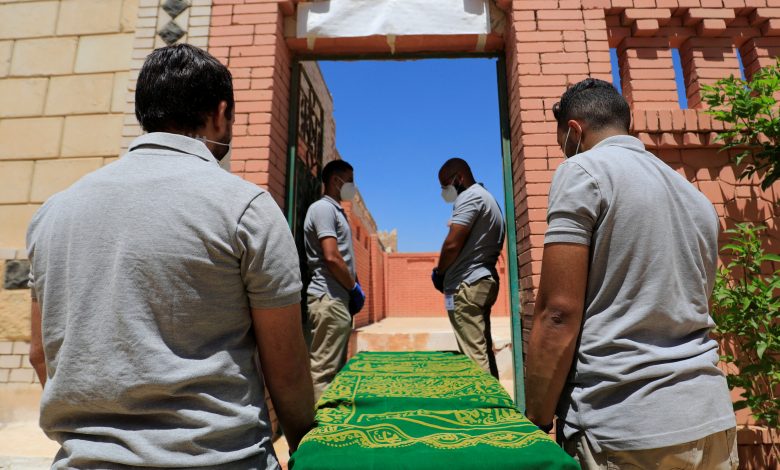 موظفون ذكور من شركة لتقديم خدمات الدفن يحملون نعشا في ضواحي القاهرة، مصر، 19 مايو 2021. رويترز، عمرو عبد الله دلش.