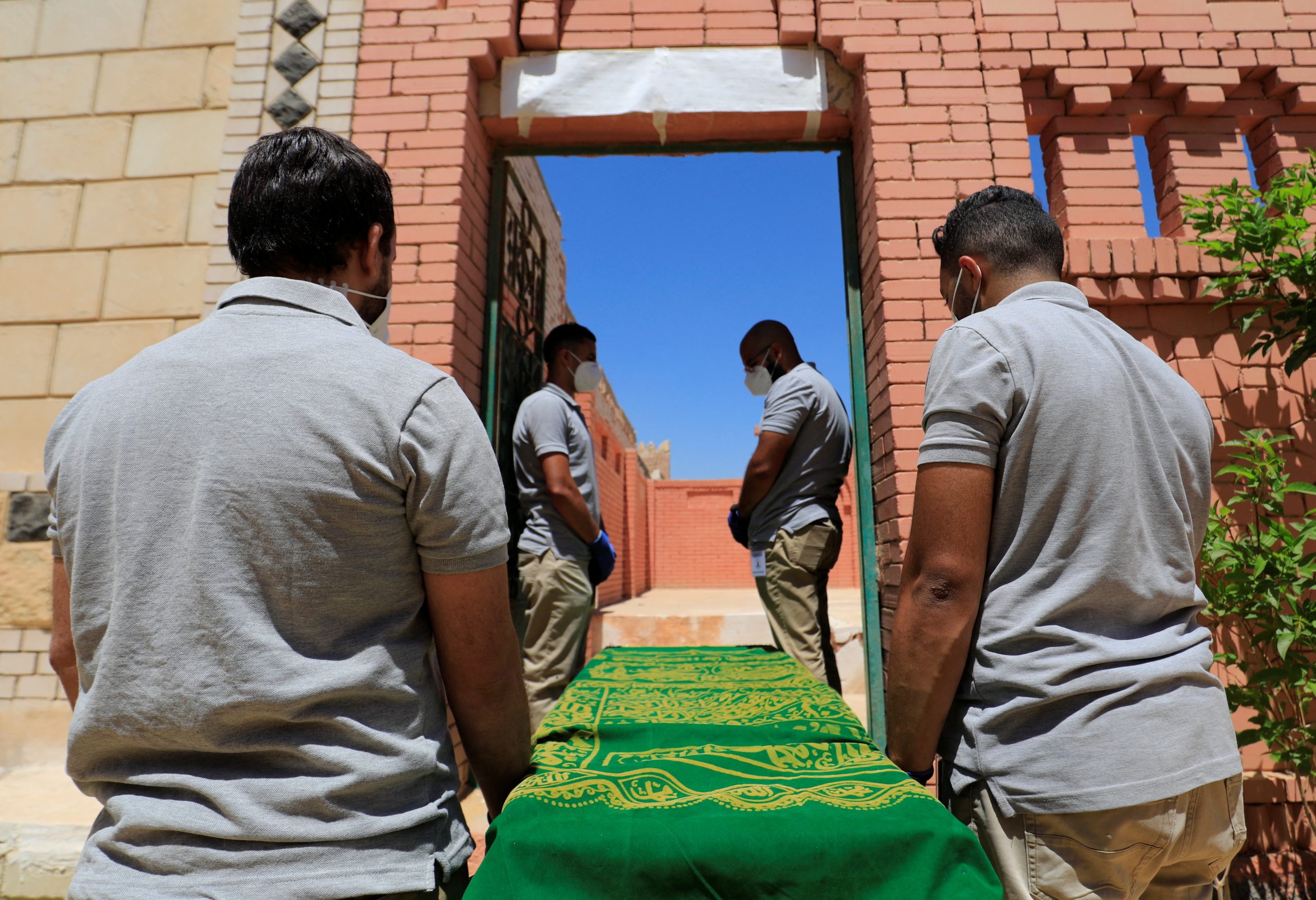 Male employees of a funeral service company carry a coffin in the outskirts of Cairo, Egypt, 19 May 2021. Reuters, Amr Abdallah Dalsh.