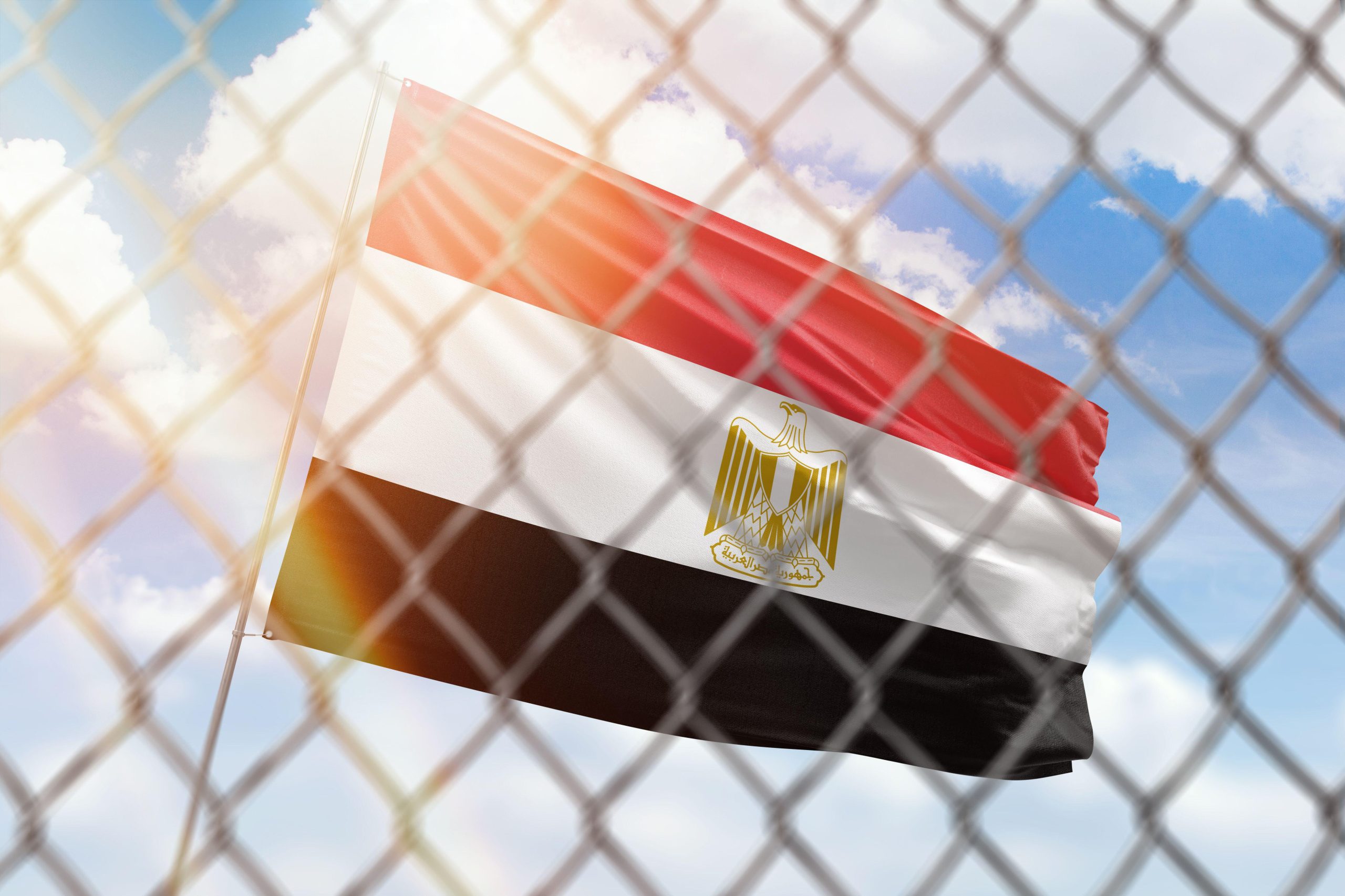 An illustration depicting a steel mesh set against a backdrop of a blue sky, accompanied by a flagpole bearing the flag of Egypt, 24 April 2022. Source: Alamy via Reuters.