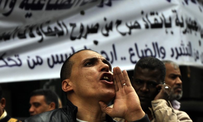 عمال وموظفون مصريون من شركة المشروعات الصناعية والهندسية يشاركون في احتجاج للمطالبة برواتبهم خارج مبنى مجلس الوزراء المصري في القاهرة في ١٤ ديسمبر ٢٠١٤. المصدر: عمرو سيد/ألامي عبر رويترز.