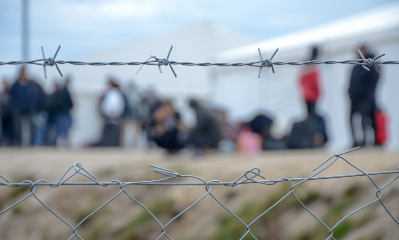 An image of barbed wire surrounding people in a refugee camp, 22 December, 2020. Source: Ajdin Kamber Via Shutterstock.
