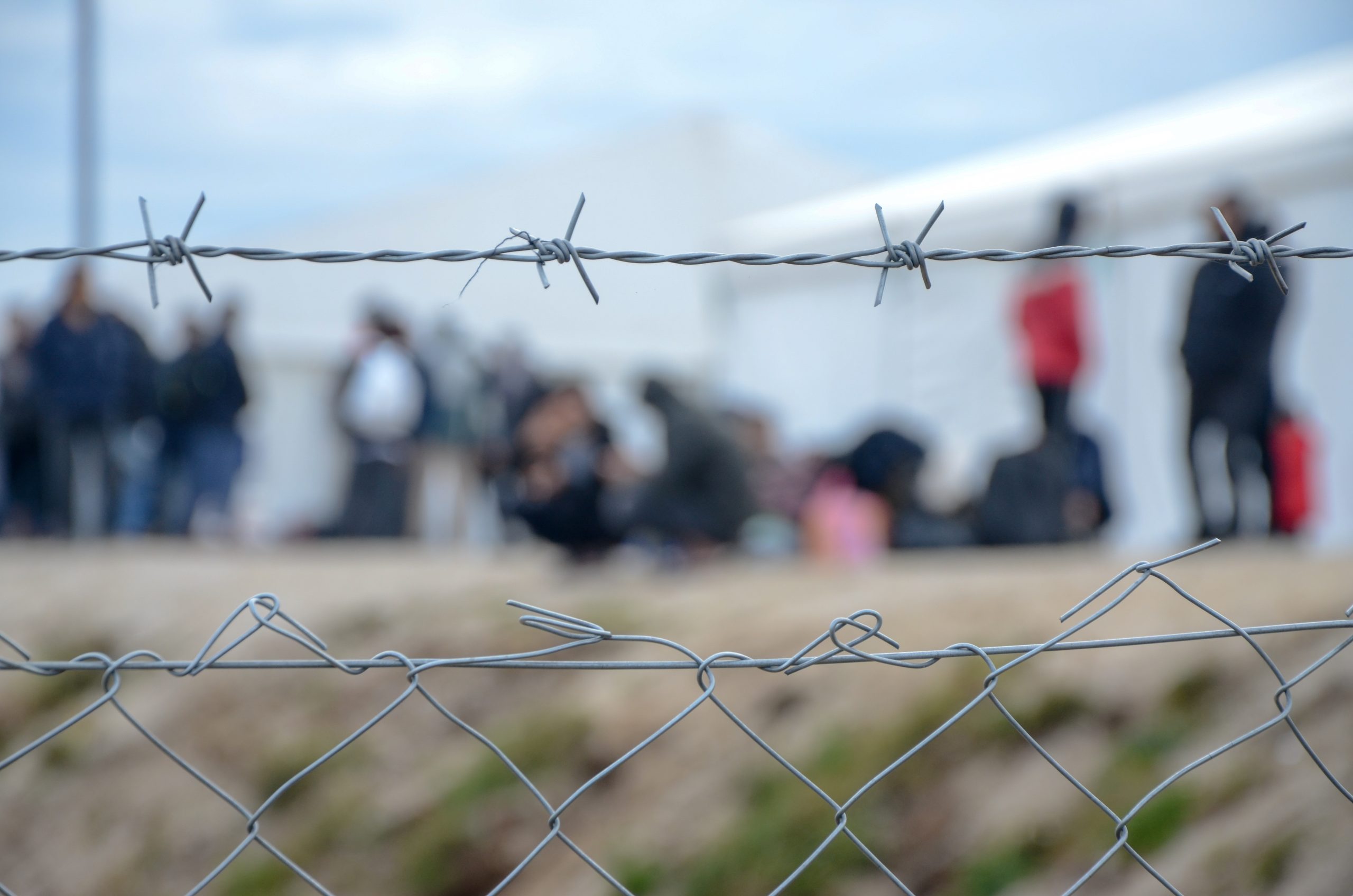 An image of barbed wire surrounding people in a refugee camp, 22 December, 2020. Source: Ajdin Kamber Via Shutterstock.