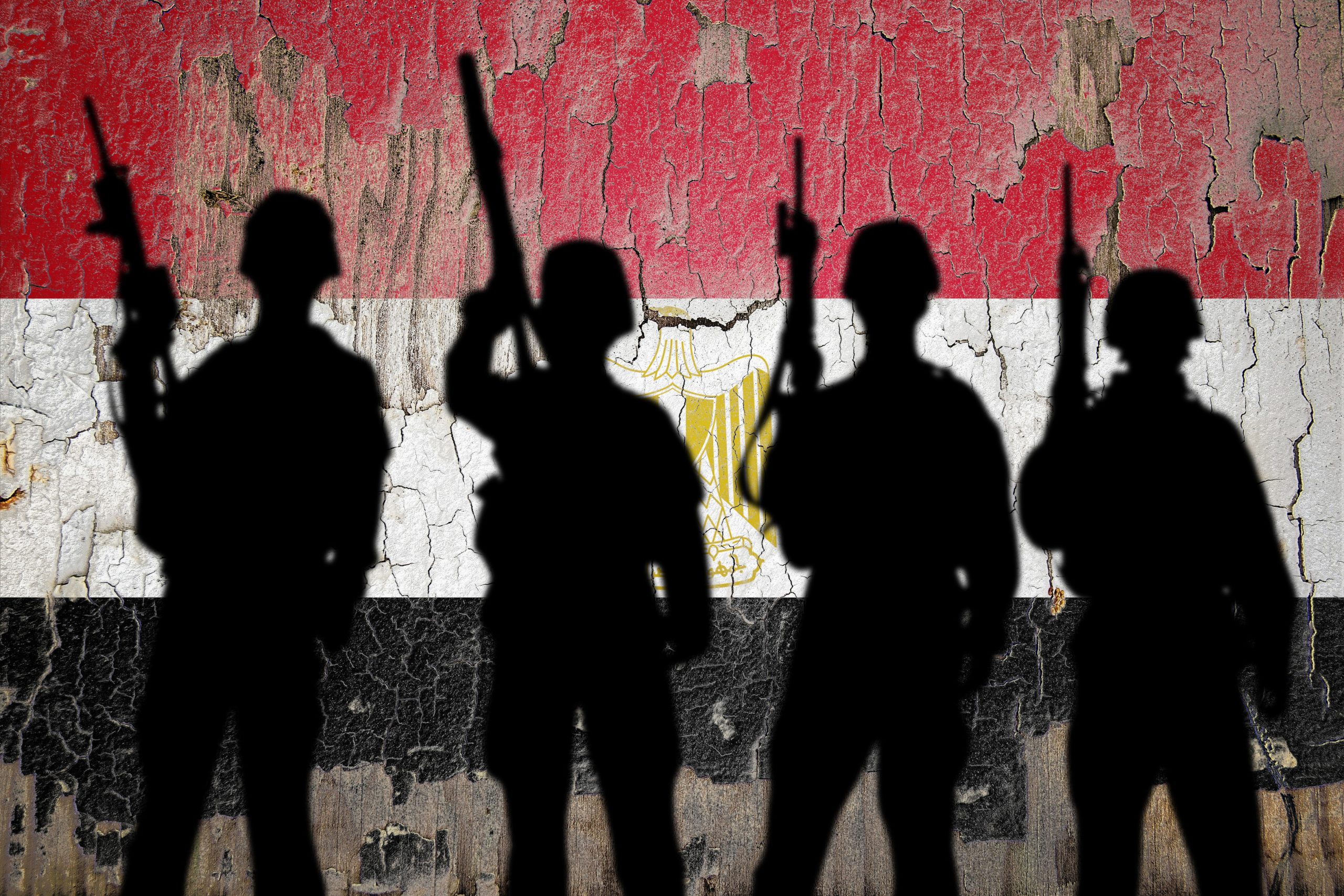 Silhouettes of soldiers standing against a weathered Egyptian flag backdrop, 13 March, 2024. Source: Zmotions via Shutterstock.