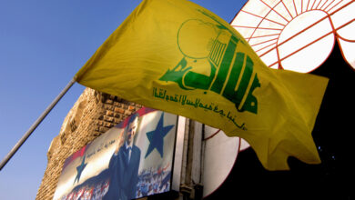 An image taken in 2007 of a Hezbollah flag in front of a poster of Bashar al-Assad at Hamadiyya Souk in Damascus, 27 December 2019. Source: John Wreford via Shutterstock.