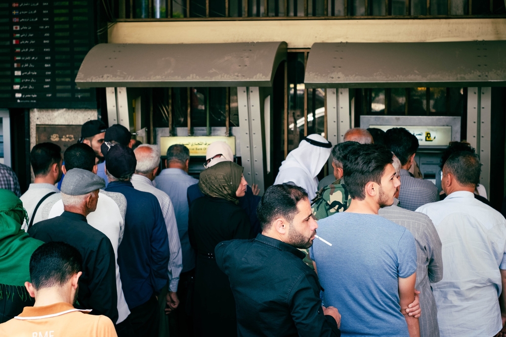 صورة لأشخاص يصطفون في طابور أمام جهاز صراف آلي تابع لبنك سورية التجاري في دمشق، 28 يونيو 2022. المصدر: هانوهِيكي عبر شترستوك.